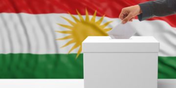 Woman's hand is voting with a waving Kurdistan flag background, 3d illustration