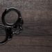 Handcuffs On Brown Wooden Table Background