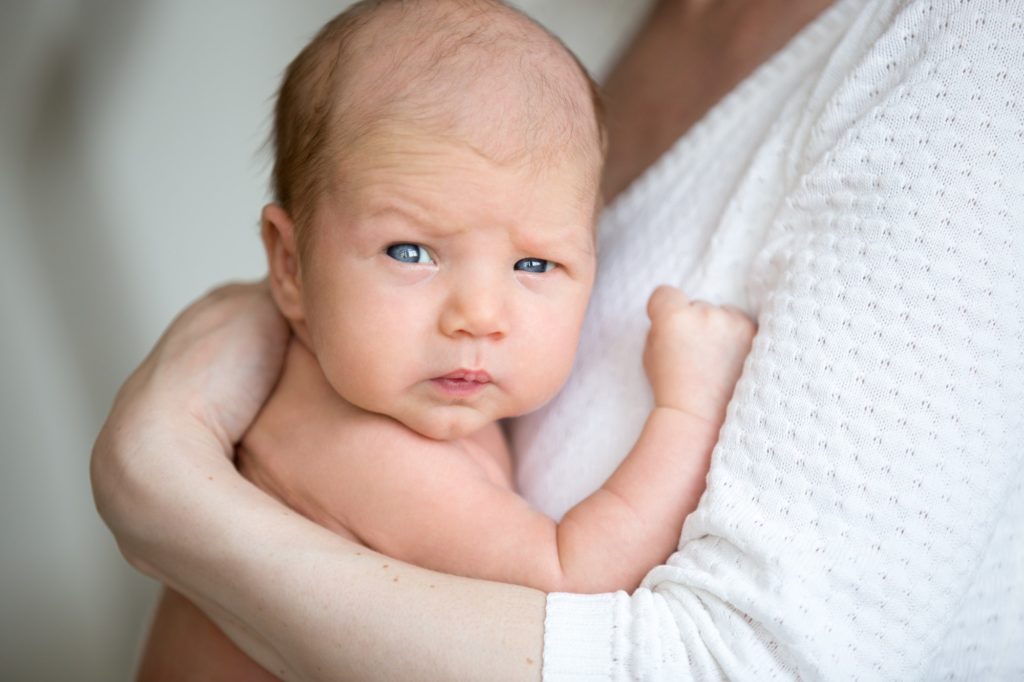 Portrait of cute newborn baby on mother arms