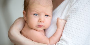 Portrait of cute newborn baby on mother arms