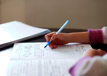 Unrecognizable girl doing homework, writing education concept, Coronavirus