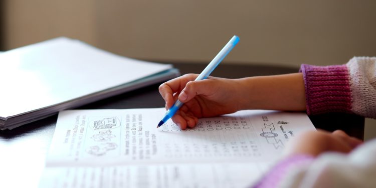 Unrecognizable girl doing homework, writing education concept, Coronavirus