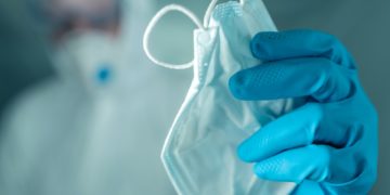 Epidemiologist offering protective respiratory mask in coronavirus concept