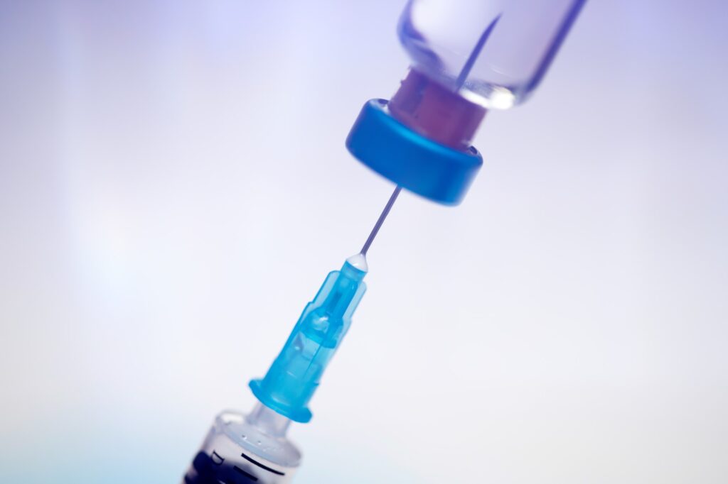 Close up on vaccine and medical syringe