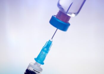Close up on vaccine and medical syringe
