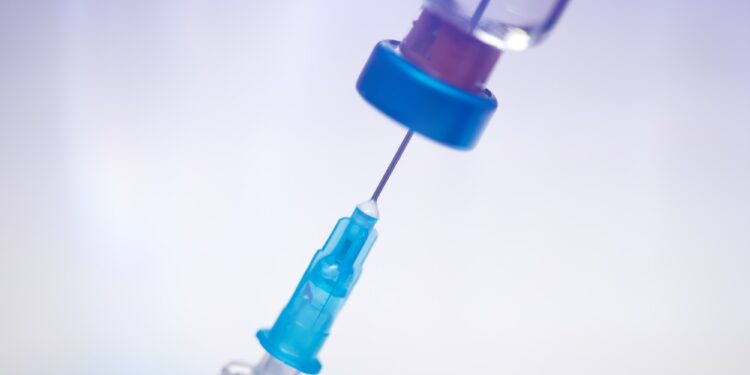 Close up on vaccine and medical syringe