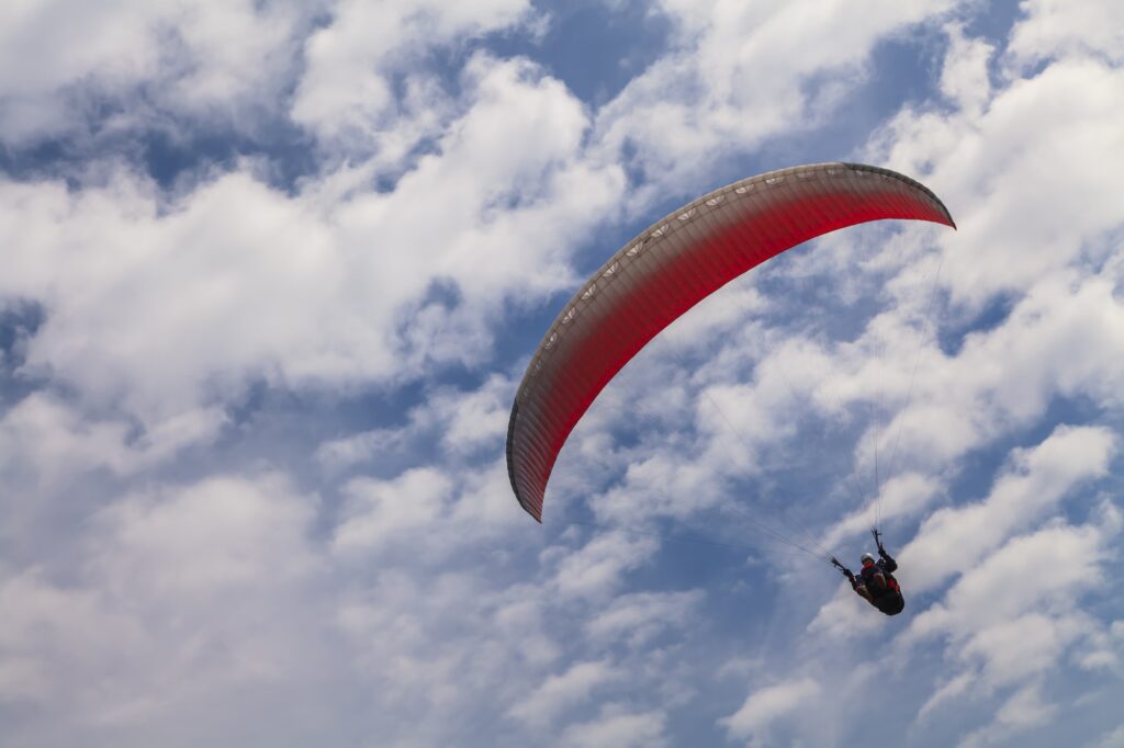 Flying paraglider on a background of blue sky and white clouds