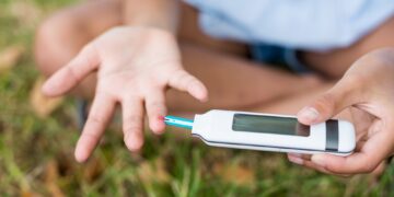 Girl testing diabetes on glucose meter