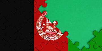 Afghanistan flag is depicted on a completed jigsaw puzzle with free green copy space on the right