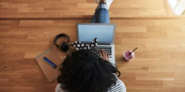 African female university student working online on a campus floor