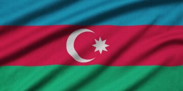 Azerbaijan flag is depicted on a sports cloth fabric with many folds. Sport team waving banner