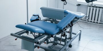 Blue colored obstetric bed indoors in the clinic cabinet at daytime