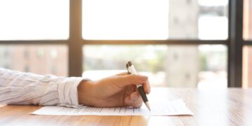Businesswoman signing a document in modern office