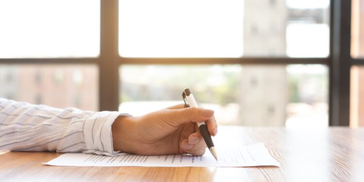 Businesswoman signing a document in modern office