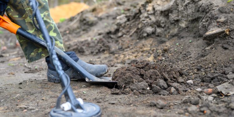 coil electronic metal detector device for search a treasure on ground background