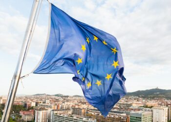 EU flag fluttering by wind above Barcelona