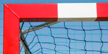 Football or handball goal with red and white goalpost
