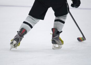 Hitting the Ice for the hockey game - close Up of skates and a hockey stick