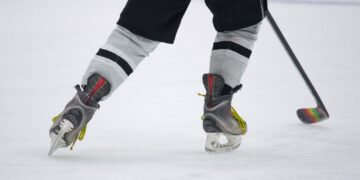 Hitting the Ice for the hockey game - close Up of skates and a hockey stick