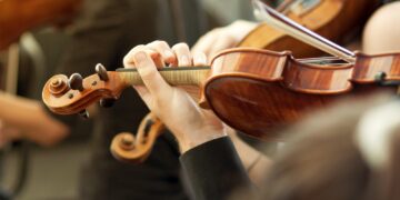 Member of classical music orchestra playing violin on a concert
