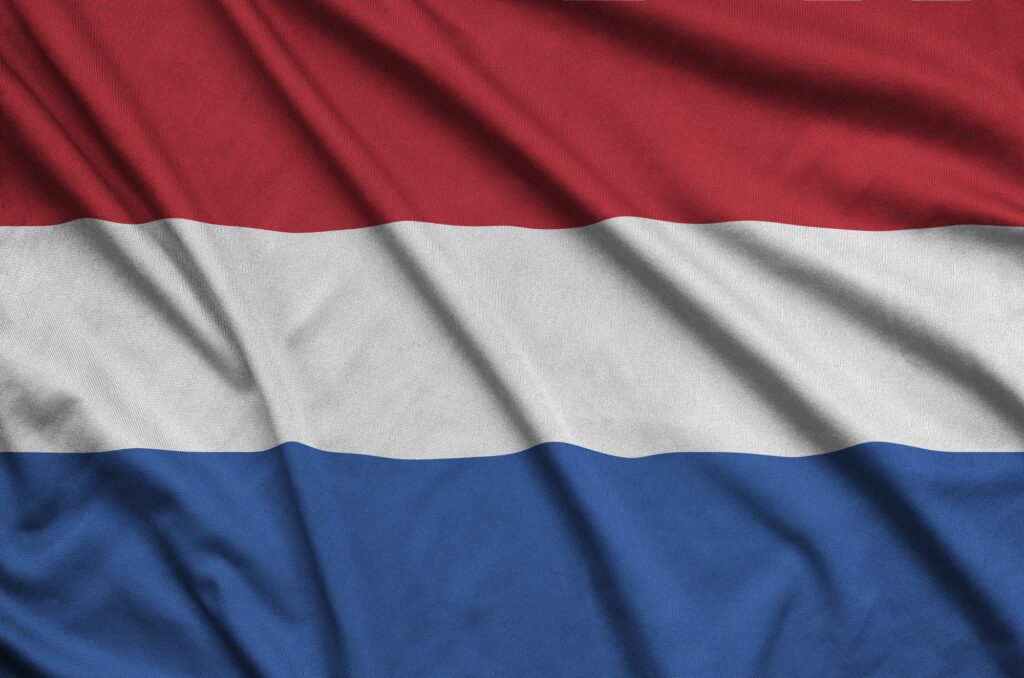 Netherlands flag is depicted on a sports cloth fabric with many folds. Sport team waving banner