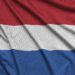 Netherlands flag is depicted on a sports cloth fabric with many folds. Sport team waving banner