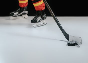 partial view of professional sportsman playing hockey on black