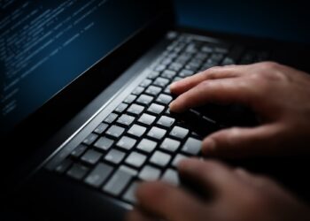 Programmer or computer hacker typing on laptop keyboard