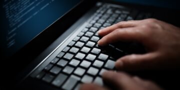 Programmer or computer hacker typing on laptop keyboard