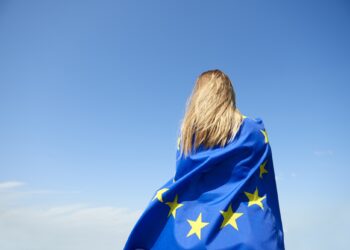 Rear view of young woman covered with European Union Flag