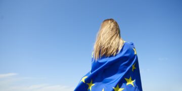 Rear view of young woman covered with European Union Flag