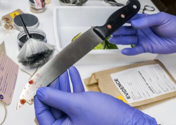 Scientist takes samples of a knife in laboratory, conceptual image