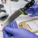 Scientist takes samples of a knife in laboratory, conceptual image