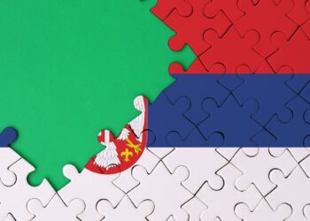 Serbia flag is depicted on a completed jigsaw puzzle with free green copy space on the left side.
