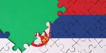 Serbia flag is depicted on a completed jigsaw puzzle with free green copy space on the left side.