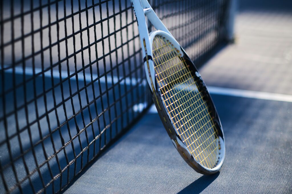 Tennis racquet is standing near tennis net