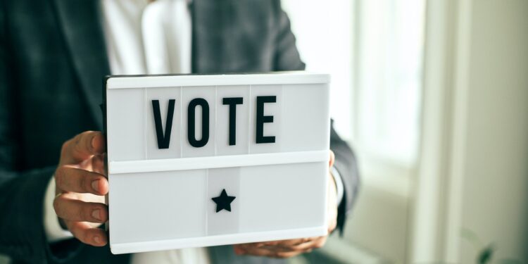 The word VOTE written on lightbox in men's hands. Election concept