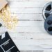 Top view of film reels, popcorn and movie clapper on wooden table, Movie time concept