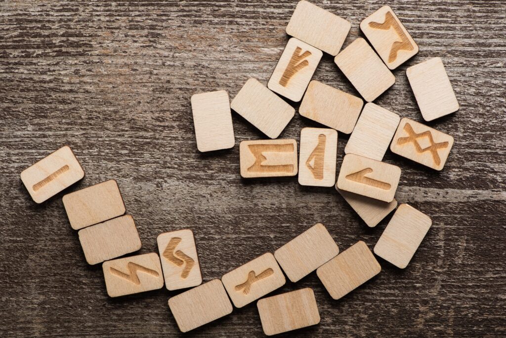 Top View of Runes With Symbols on Wooden Background