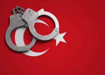 Turkey flag and police handcuffs. The concept of crime and offenses in the country.