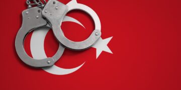 Turkey flag and police handcuffs. The concept of crime and offenses in the country.