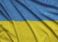 Ukraine flag is depicted on a sports cloth fabric with many folds. Sport team waving banner