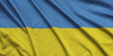 Ukraine flag is depicted on a sports cloth fabric with many folds. Sport team waving banner