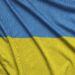 Ukraine flag is depicted on a sports cloth fabric with many folds. Sport team waving banner