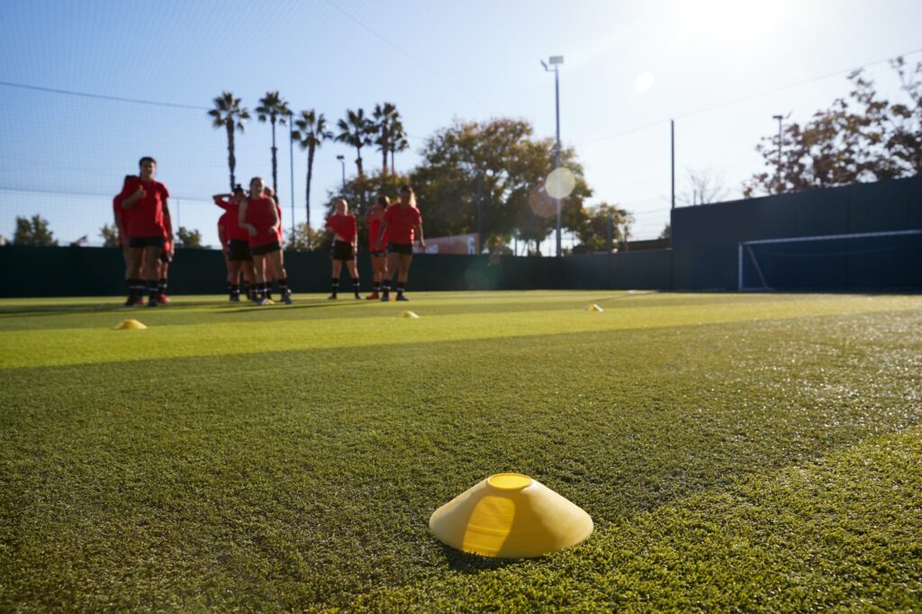 Womens Football Team Training For Soccer Match On Outdoor Astro Turf Pitch