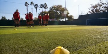 Womens Football Team Training For Soccer Match On Outdoor Astro Turf Pitch