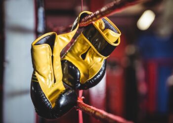 Yellow boxing gloves hanging off the boxing ring