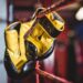 Yellow boxing gloves hanging off the boxing ring