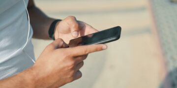 Young man hands using smart phone app for sport